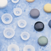 Assorted silicone end caps in various colours and sizes displayed on a textured blue surface for tube and pipe protection