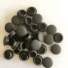 Pile of mid-grey silicone rubber end caps used for sealing pipe ends, tubing, and threaded fittings in industrial or home applications