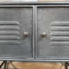 Close-up of industrial grey metal storage cabinet with two doors, rustic textured finish, and round knobs