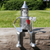 Mini Tin Man statue sitting on wooden beam with axe and heart detail