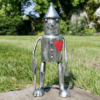 Small Tin Man ornament with axe and heart on grass lawn